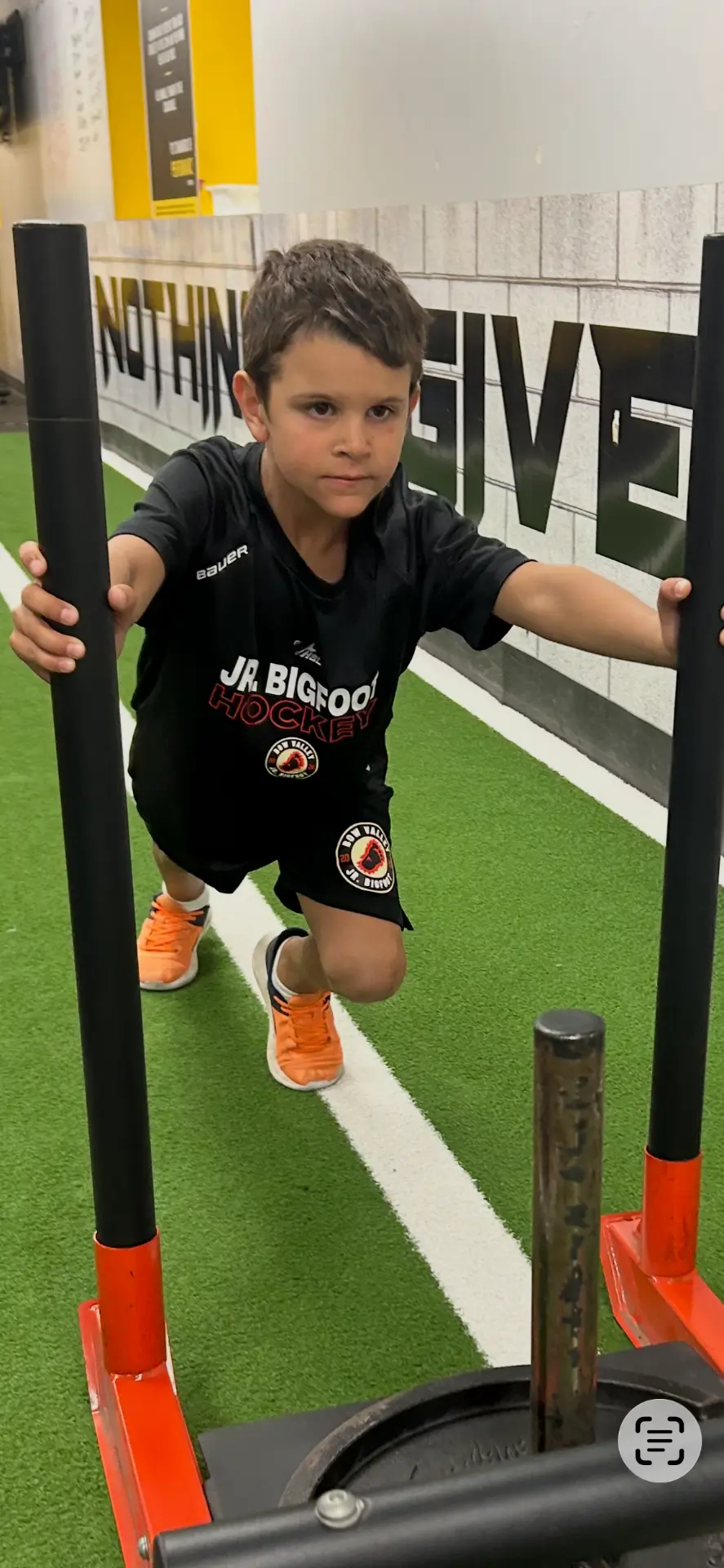Jr. Bigfoot athlete pushing a weighted sled at the P3 Training Center